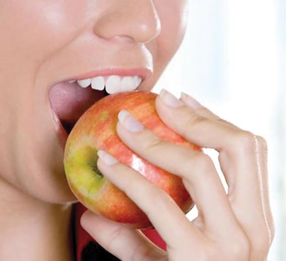 comendo maca com dentes brancos